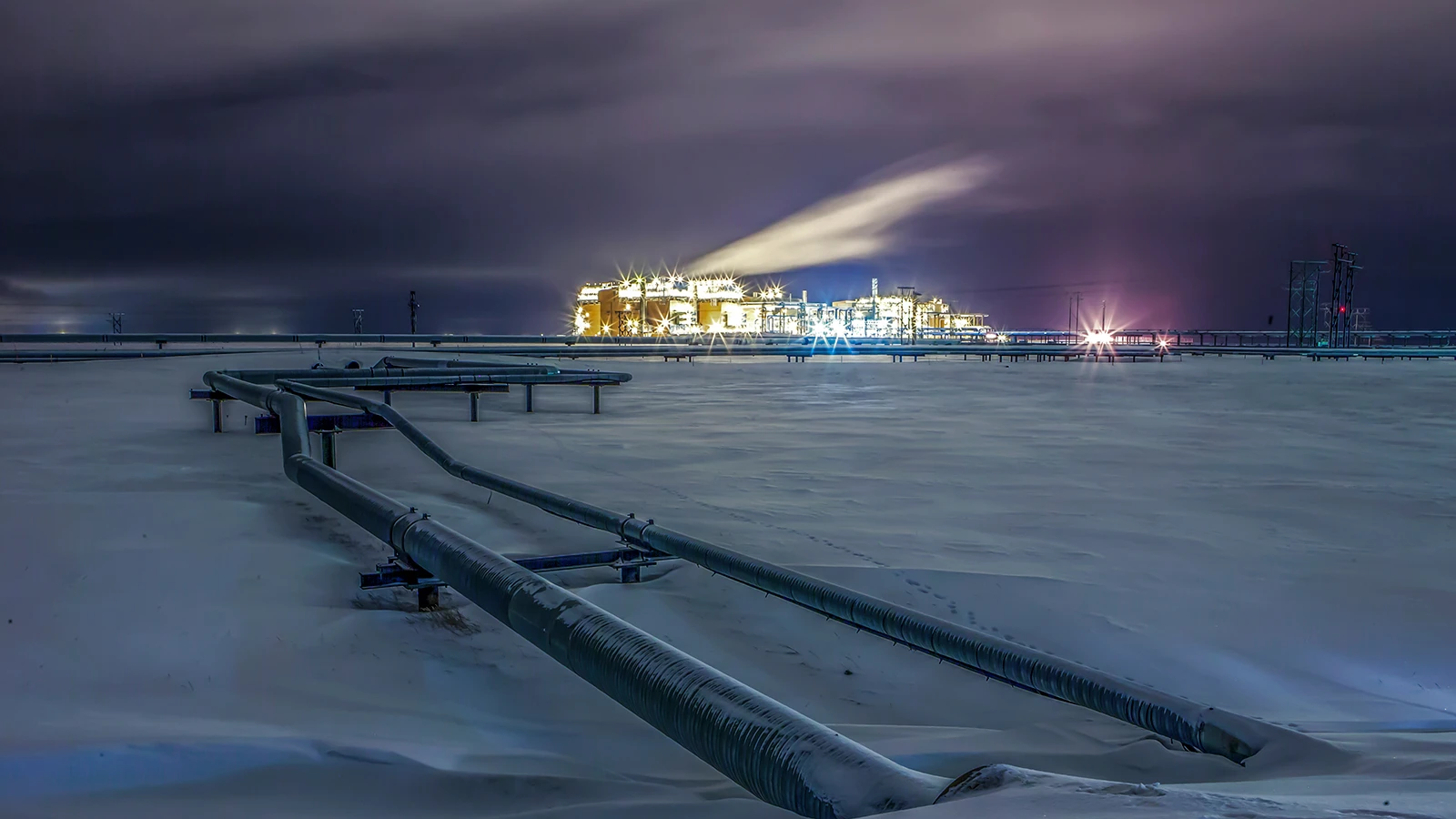 Oil fields at night covered in snow