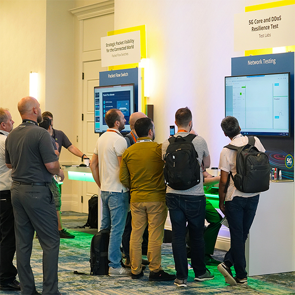 Group of people standing around a Network Testing demo station