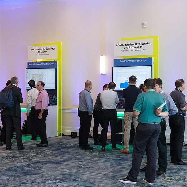 Group of people standing around a Service Provider Security demo station