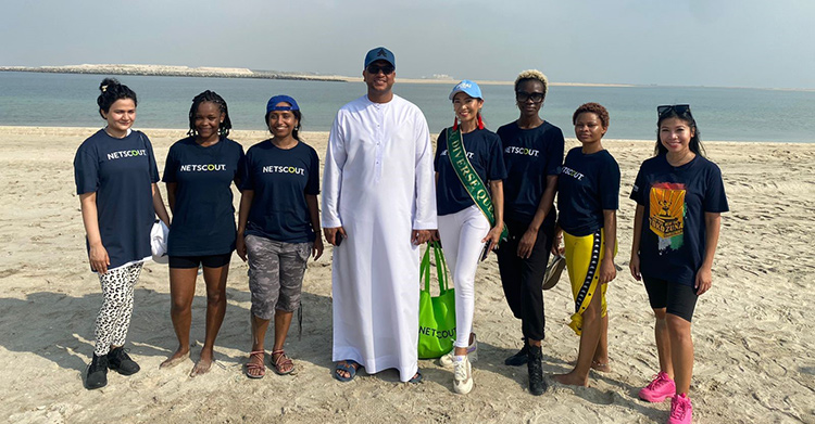 NETSCOUT volunteers in NETSCOUT t-shirts standing on the shoreline