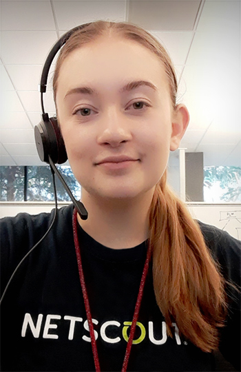 Kaitlyn Simpson, a young woman with long red hair wearing a black NETSCOUT t-shirt