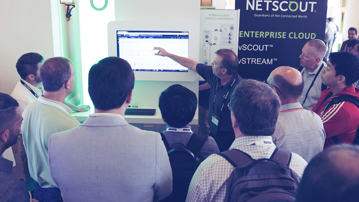 People gathered around a NETSCOUT demonstration booth at a conference.
