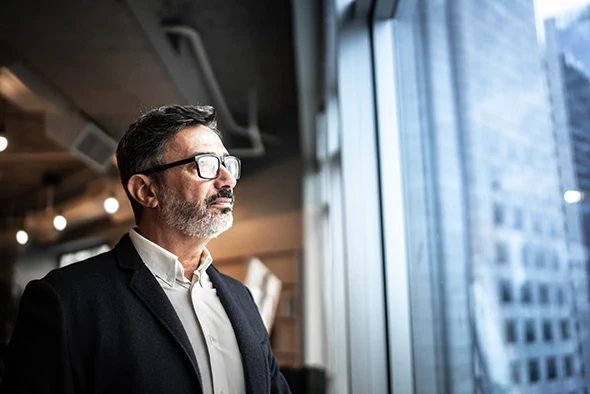 Man staring out office windows