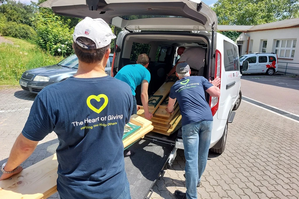 Group of volunteers loading lumber into a van