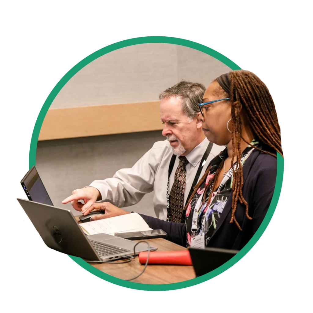 Two people working on laptops