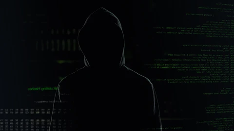 Hooded figure in dark shadow