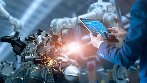 Person using tablet near manufacturing equipment