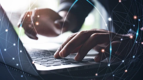 A close up of hands using a laptop keyboard with an overlay of circles and dots