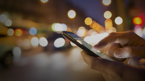 Hand on cell phone searching on a street