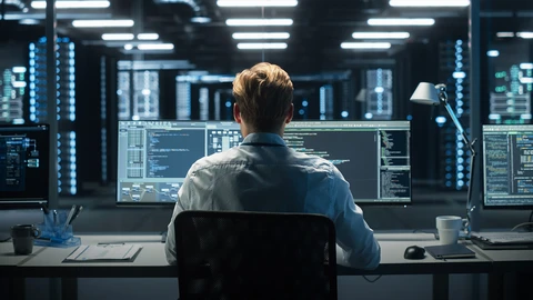 Gentlemen looking at 2 monitors in NOC