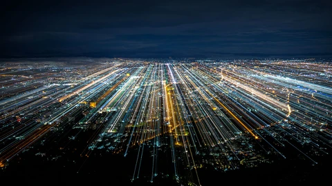 City at night looking over horizon with lines of lights depicting underground cables