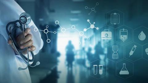 Portion of person in lab coat holding stethoscope with blurred background of hospital waiting room