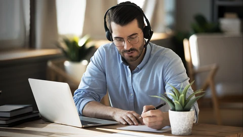 Gentlemen on headset in front of a laptop