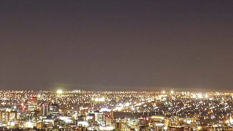 city at night from far away, brown tint