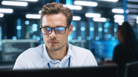 Gentlemen in datacenter reviewing content on a monitor