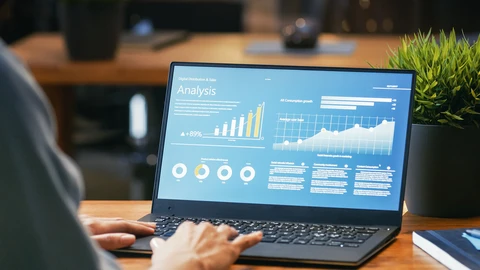 Hands on laptop reviewing analysis report