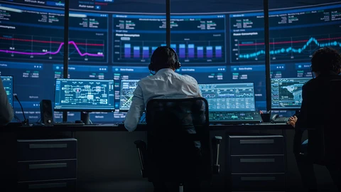 Cybersecurity Expert Reviewing Data on Monitors