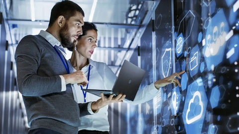 2 people in Operations Lab review information on laptop