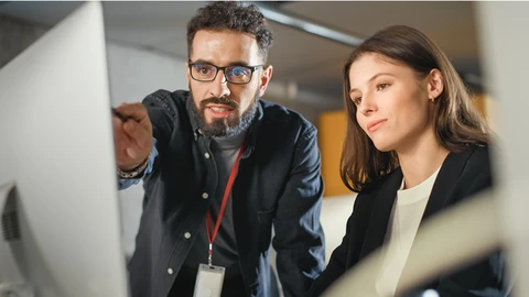 2 co-works looking at a monitor together.