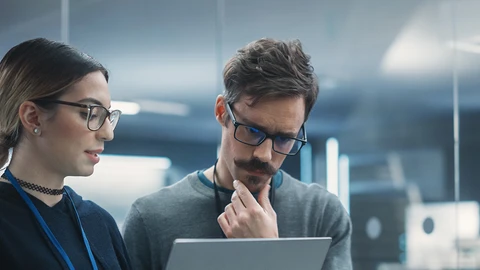 2 employees looking over laptop