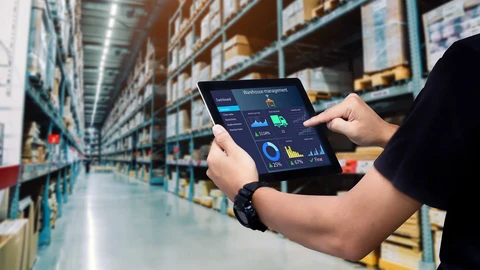 Worker on tablet managing retail warehouse