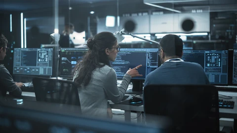 IT workers reviewing data on monitors