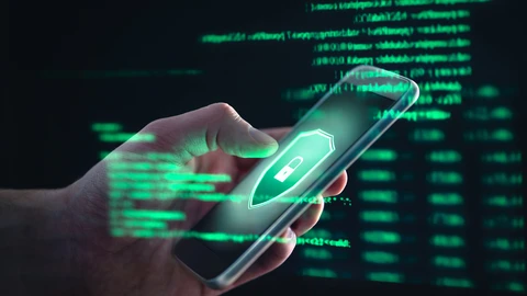 Phone with lock and shield with green network background behind user's hand