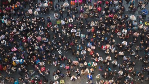 Crowd standing outside looking up at camera
