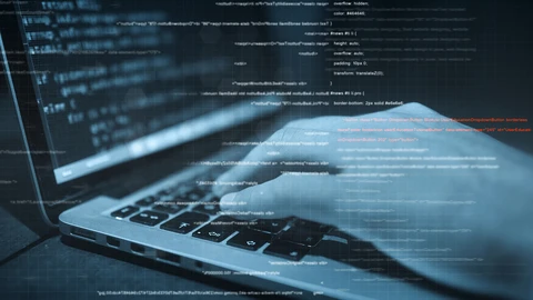 Hands typing on laptop with code