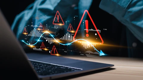 Laptop with exclamation points showing errors floating in front of worker
