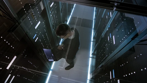man on laptop in datacenter