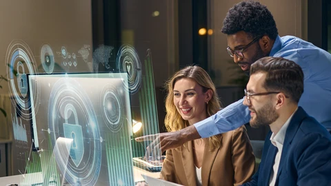People group together reviewing something on monitor