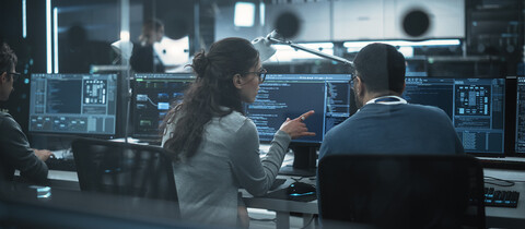 IT workers reviewing data on monitors