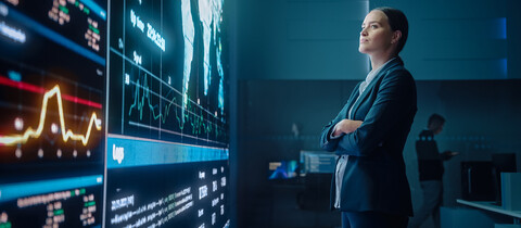Person standing in front of dashboard with map on a giant screen
