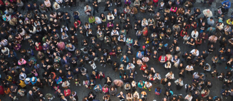 Crowd standing outside looking up at camera