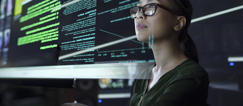 Woman with glass reviewing smart data
