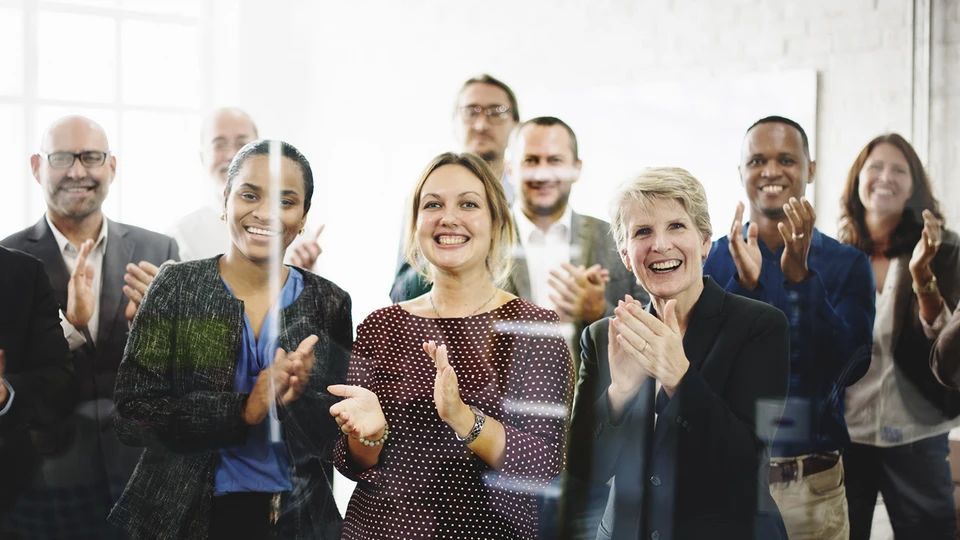 People behind glass clapping