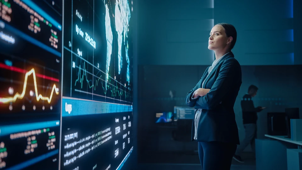 Person standing in front of dashboard with map on a giant screen