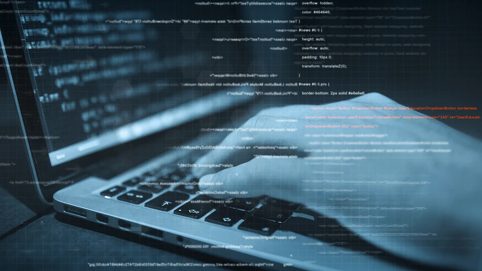 Hands typing on laptop with code