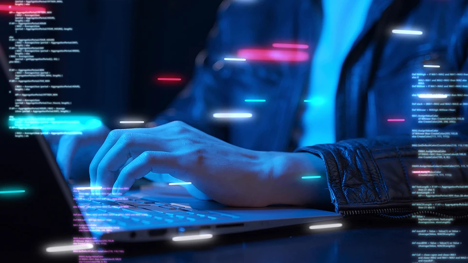 Person typing on keyboard with code in foreground