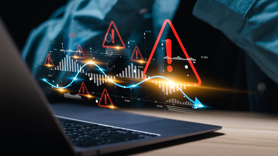 Laptop with exclamation points showing errors floating in front of worker