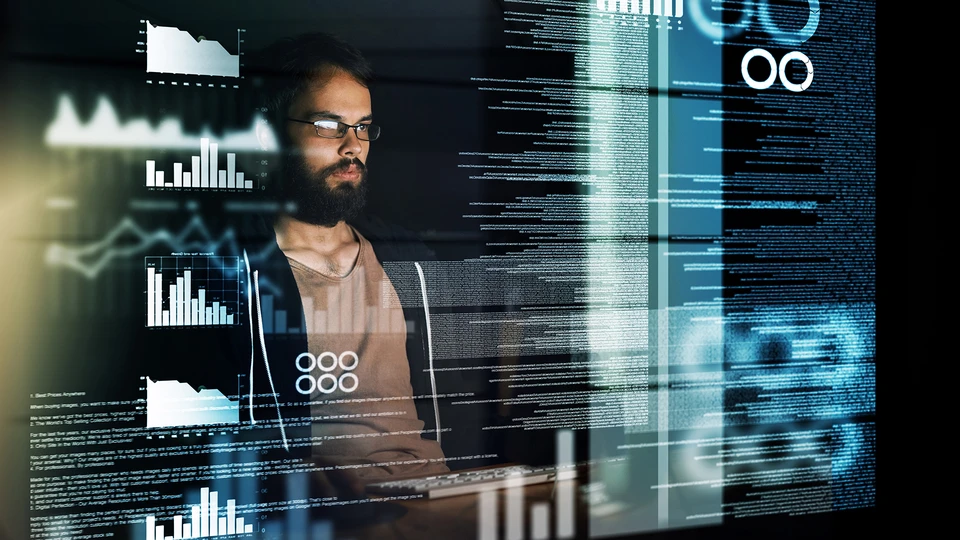 Man in glasses working on computer with dashboard imposed in front of him